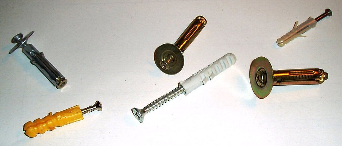 Beyaz zemin üzerinde plastik ve metal dübeller ile vidalar